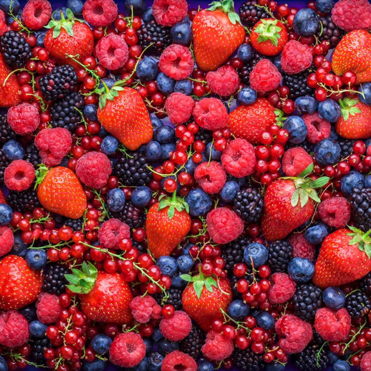 头顶上的浆果特写五颜六色的混合草莓，蓝莓，覆盆子，黑莓，红醋栗在工作室的黑暗背景