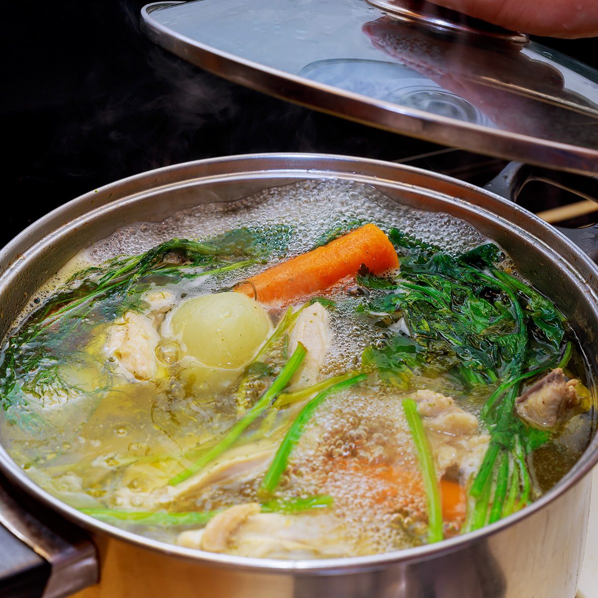锅中准备鸡骨汤的材料鸡肉，洋葱，芹菜根，胡萝卜，欧芹