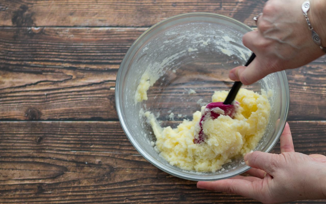 双手握住碗，用锅铲搅拌碗里的食材。怎样把黄油和糖搅成奶油