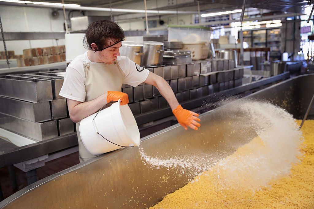 2016年6月27日，特雷弗·赫策尔在威斯康辛州特蕾莎的威德默奶酪酒窖里给一桶科尔比奶酪加盐