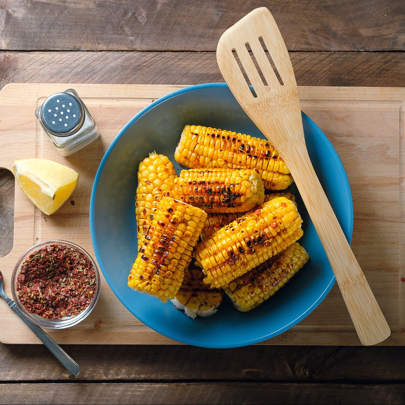 黄色的玉米棒，在木桌子的背景上撒上香料，上面撒上香料。烹饪自制食品的概念。素食和纯素食，饮食。有机农产品。