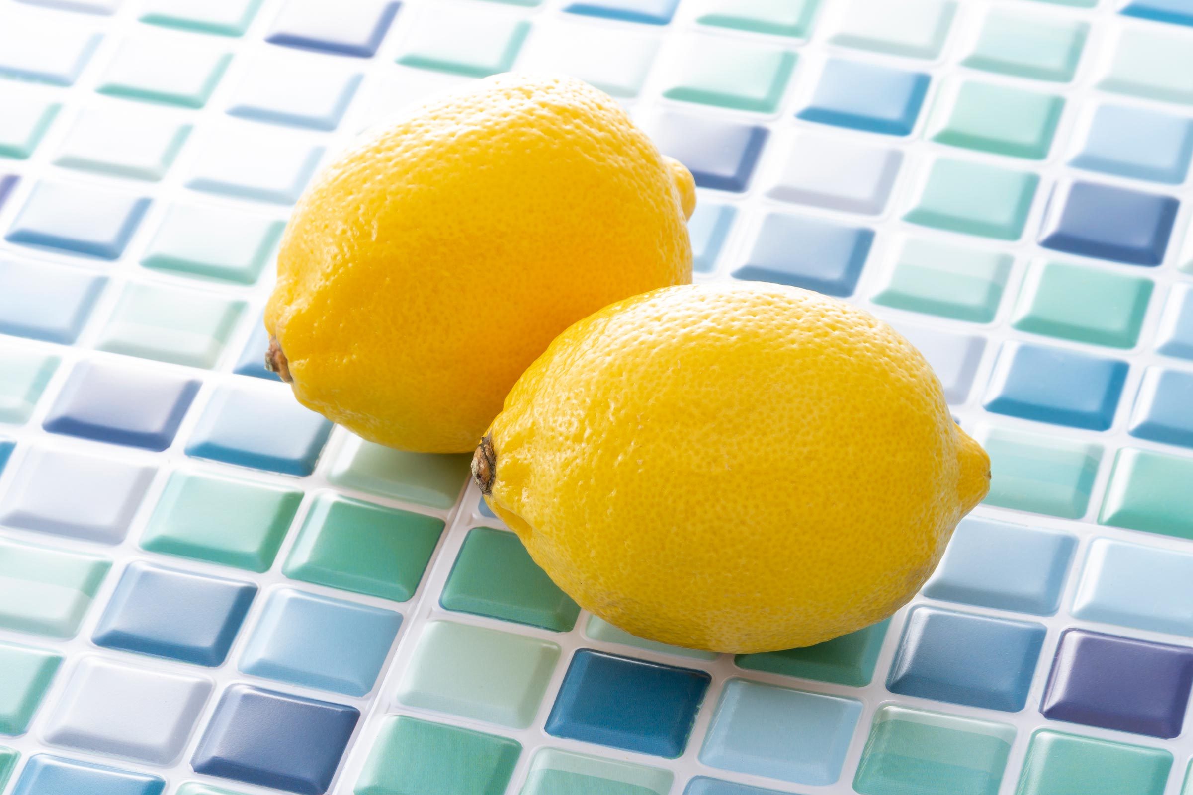 蓝色浴室瓷砖背景上的两个柠檬