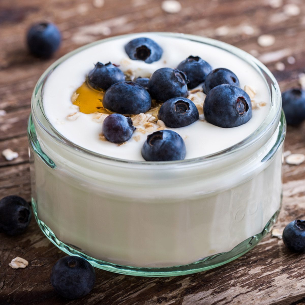 旧木桌上的酸奶、新鲜蓝莓和燕麦片。特写镜头的细节。Shutterstock ID 298272557