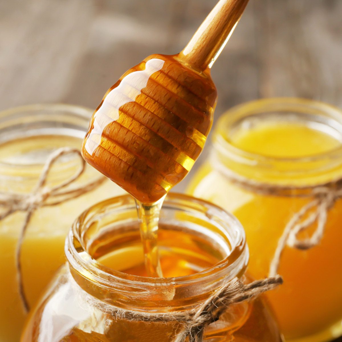 把芳香的蜂蜜倒进罐子，特写;伤风ID 764193367