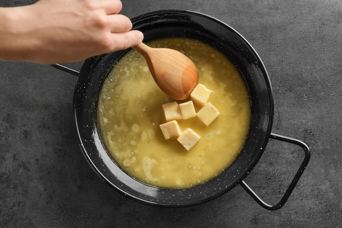 特写，女人在煎锅上搅拌融化的黄油