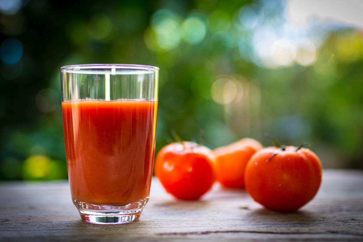 番茄汁在透明的玻璃在木桌上