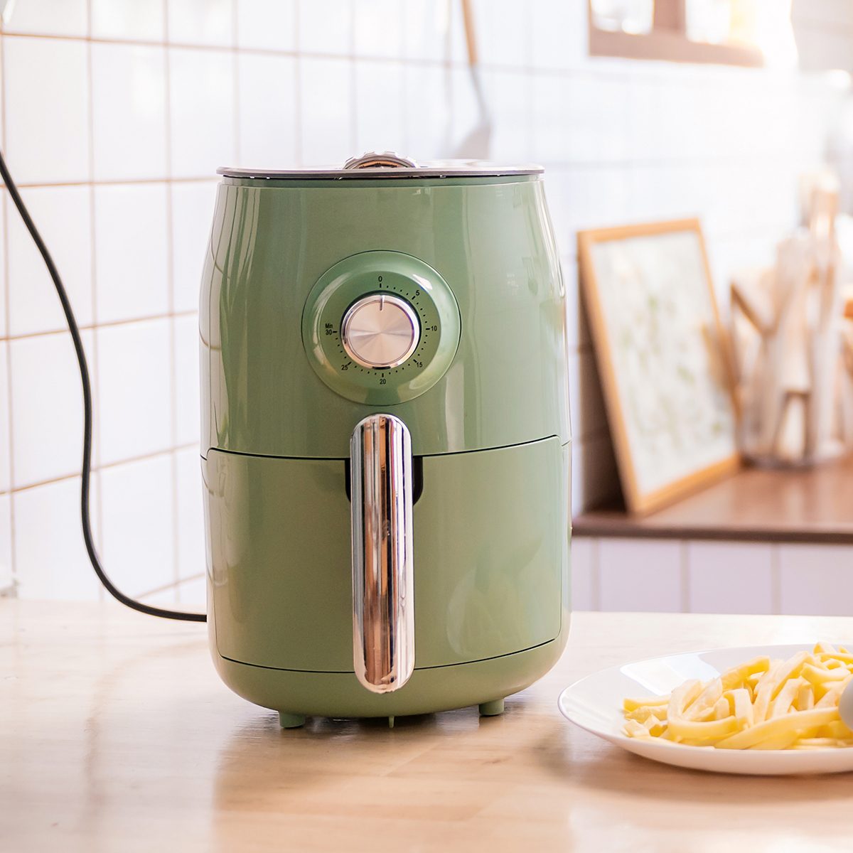 空气炸锅机烹饪土豆在厨房的家庭。新常态的家庭烹饪生活方式。科技环保家居智能设备。空气炸锅机与法式油炸概念