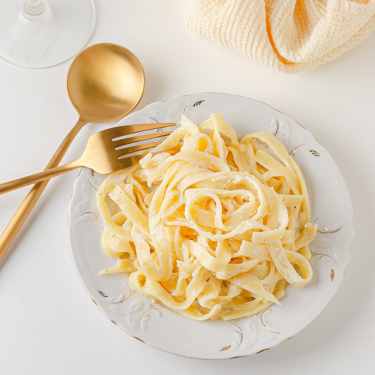 传统的意大利意面在白色的桌子上，金色的器具